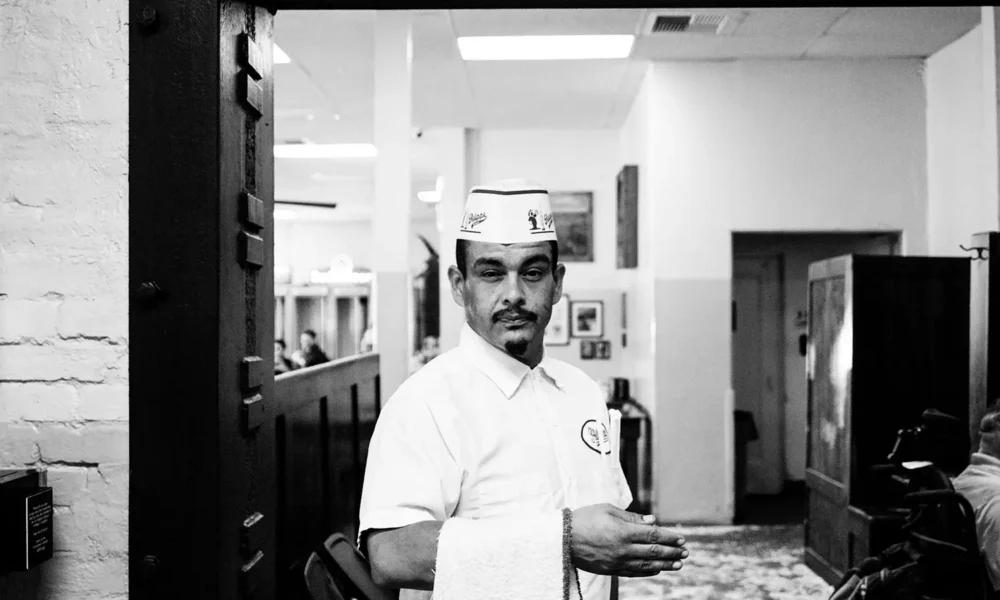 Middle aged man working in a restaurant, staring directly at the camera